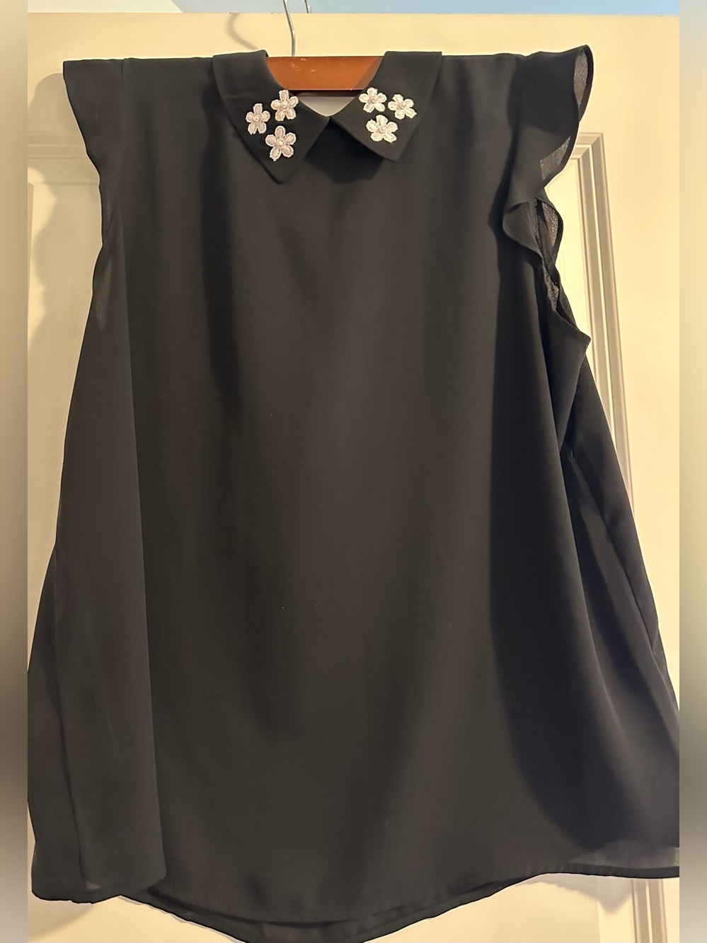 Black Sleeveless Blouse with Floral Collar Embellishment